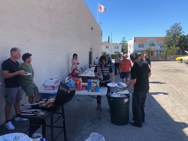 people standing around outdoor BBQ